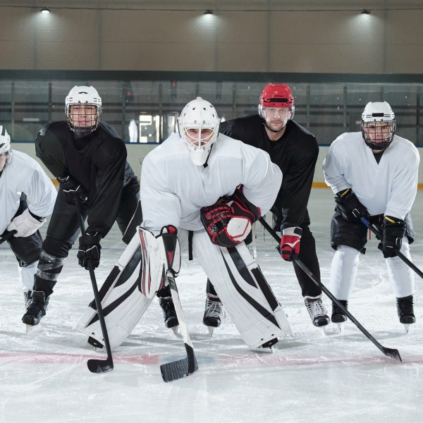 Professional hockey players bending forwards while standing on ice rink