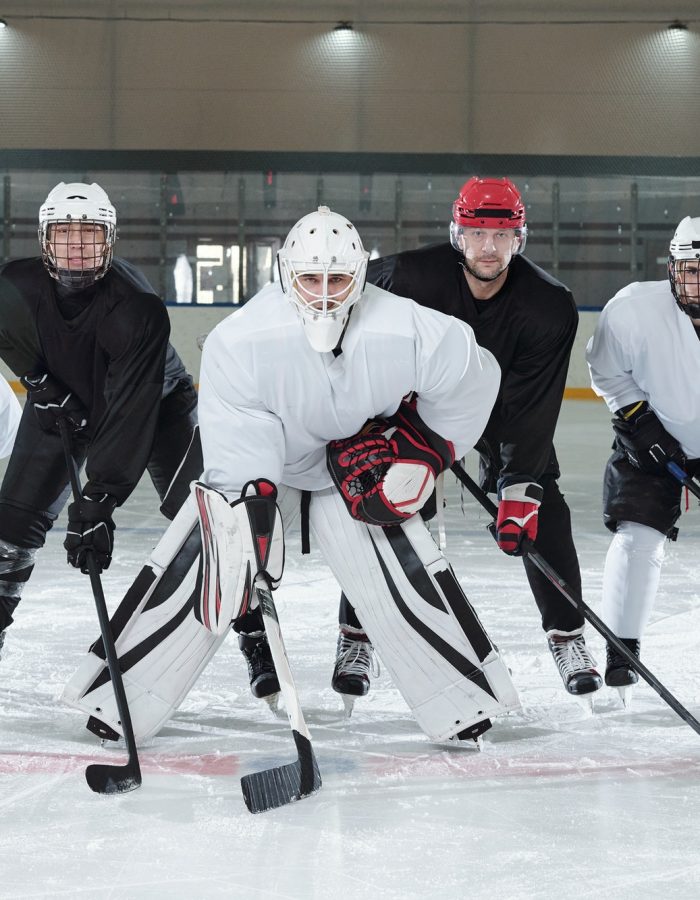 Professional hockey players bending forwards while standing on ice rink